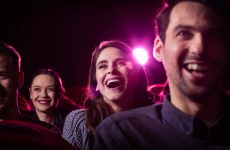 Group of happy people watching funny movie in the cinema. Close up of faces.